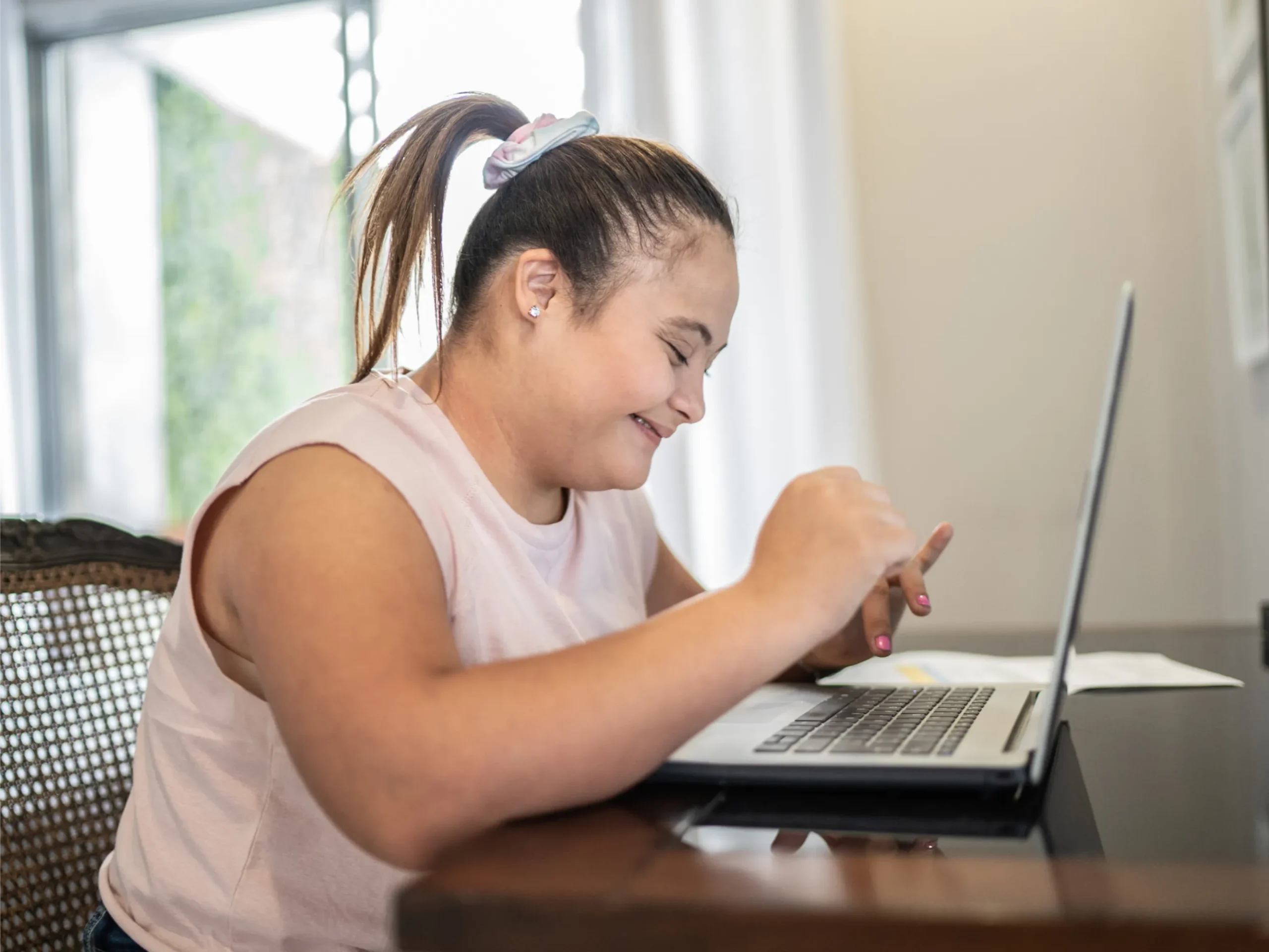 Young adult woman with disability using computer